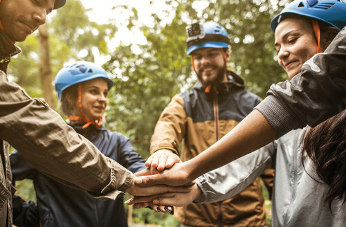 group of smiling young adults in blue helmets