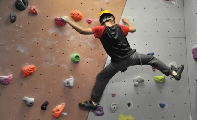 boy climbing n bouldering wall