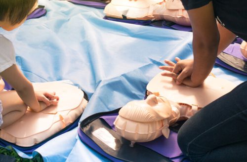 group practicing cpr on dummies