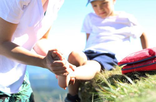 adult first aider checking a boys foot