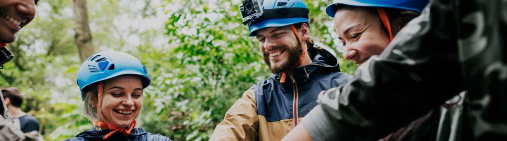 group of smiling young adults in helmets