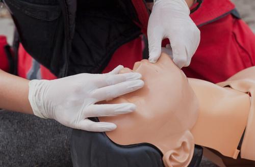 person preparing to give CPR on a dummy