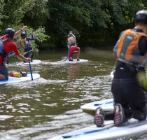 group of paddle boarders on a river