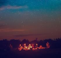 group sat around a campfire under the stars