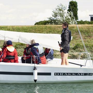 side view of group in a sailing boat