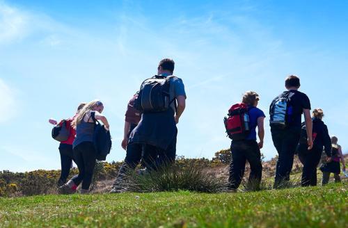 group of young people with rucksacks on heath land