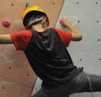 teenage boy climbing on a Bouldering wall