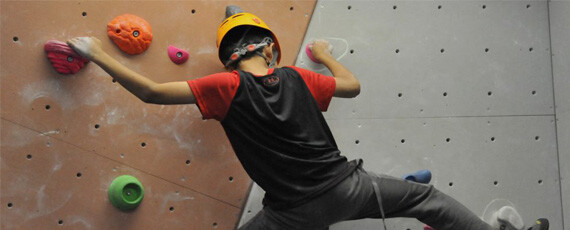teenage boy climbing on a Bouldering wall