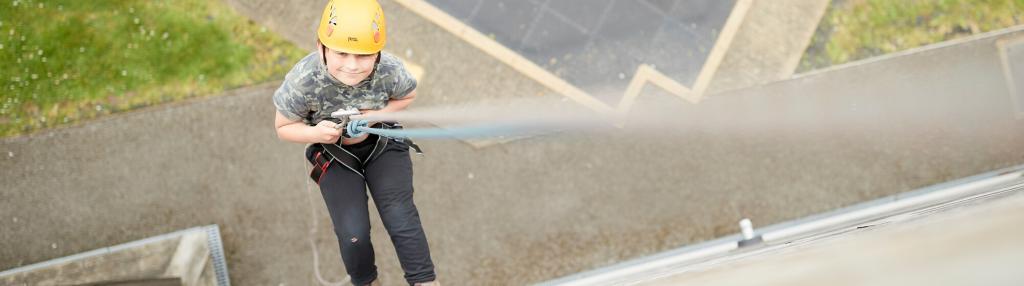 boy descending abseiling wall