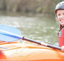 two smiling girls in kayaks