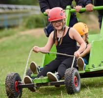 smiling girl with disability riding a go cart