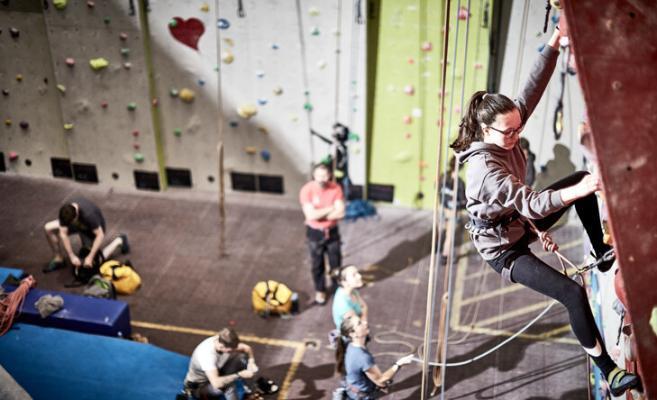 female climber ascending climbing wall