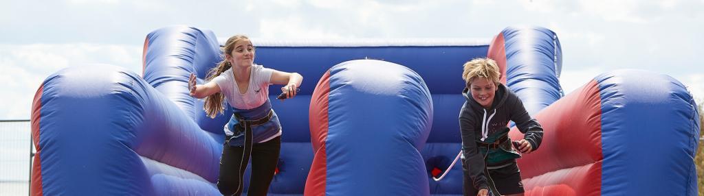 boy and girl on inflatable bungee run