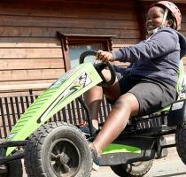 Two boys riding on pedal carts