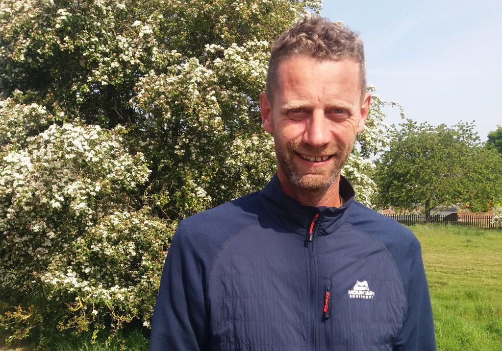 Man with hawthorn blossom tree in backgraound