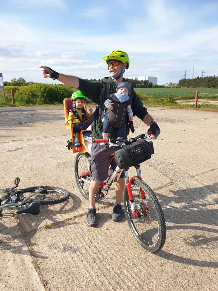 man riding bike with 2 young children