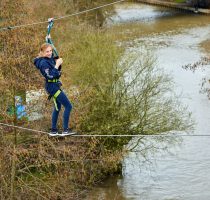 Young Person Traversing across water as part of the Harlow High Ropes Adventure.