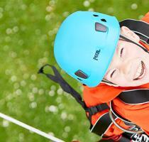 boy in bluse helmet and climbing harness