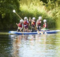 group of chilindren on large stand up paddle board