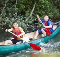 two smiling boys in a canoe