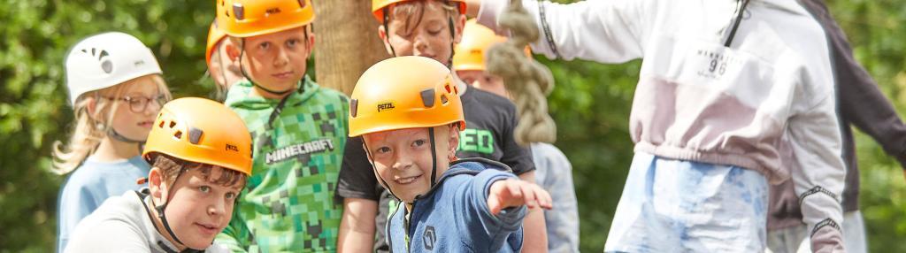 group of happy children in orange helmets outdoors