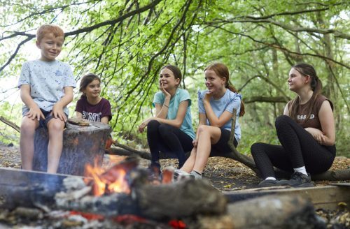 group of happy children around a camp fire